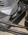 Close-up view of an off-road vehicle's rear suspension, drivetrain and axle components with visible shocks and control arms