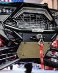 Close-up of Fastlab winch bumper with mounted winch and red strap on a Polaris RZR, highlighting front suspension and skid plate